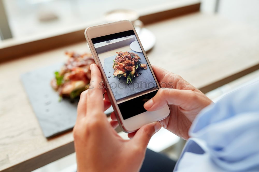 Similar – Image, Stock Photo Hand with smartphone mobile phone, photo of Burger on table