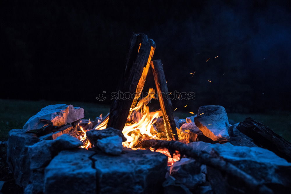 Similar – Man lights a fire in the fireplace in nature at night