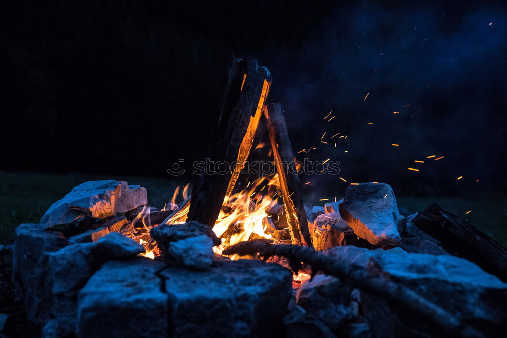 Similar – Man lights a fire in the fireplace in nature at night