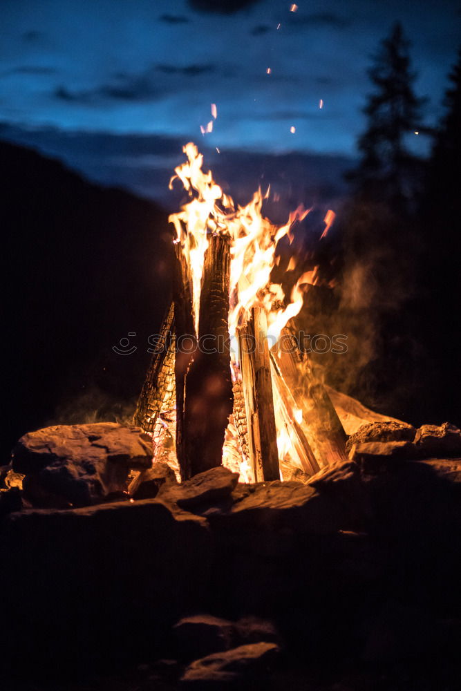 Similar – Man lights a fire in the fireplace in nature at night