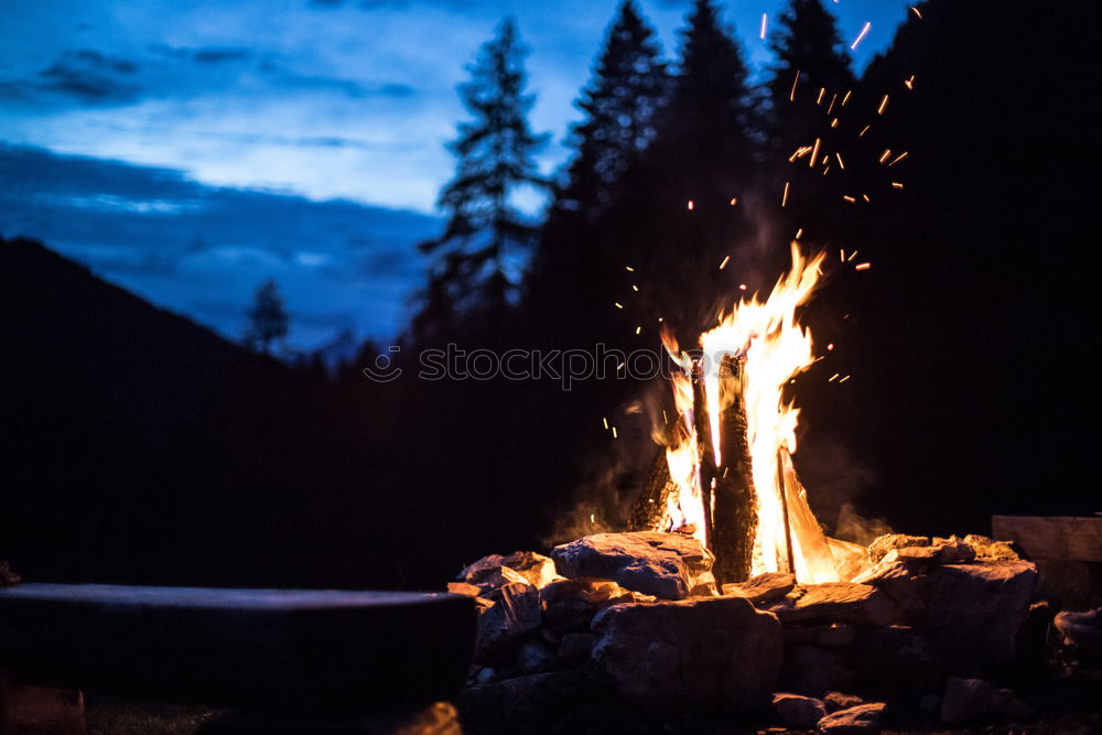 Similar – Man lights a fire in the fireplace in nature at night