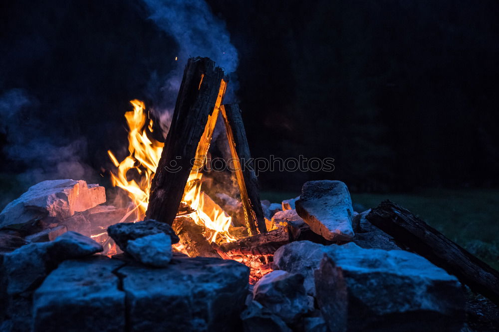 Similar – Man lights a fire in the fireplace in nature at night