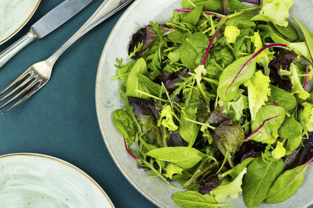 Similar – Healthy green salad with dressing on dark background