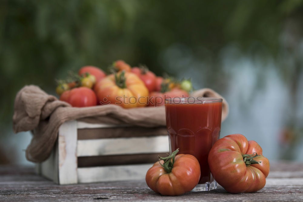 Carrot juice in a little jar among the fresh vegetables