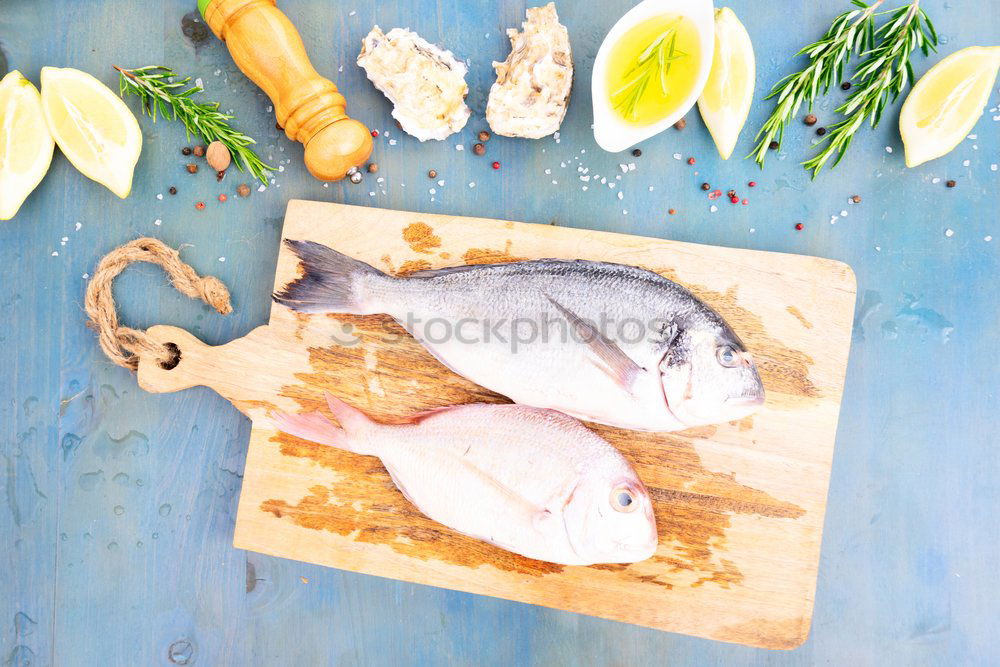 Similar – Raw prawn or shrimps and squids on light blue background, decorated with with seaweeds and lemon, top view, flat lay. Seafood cooking concept