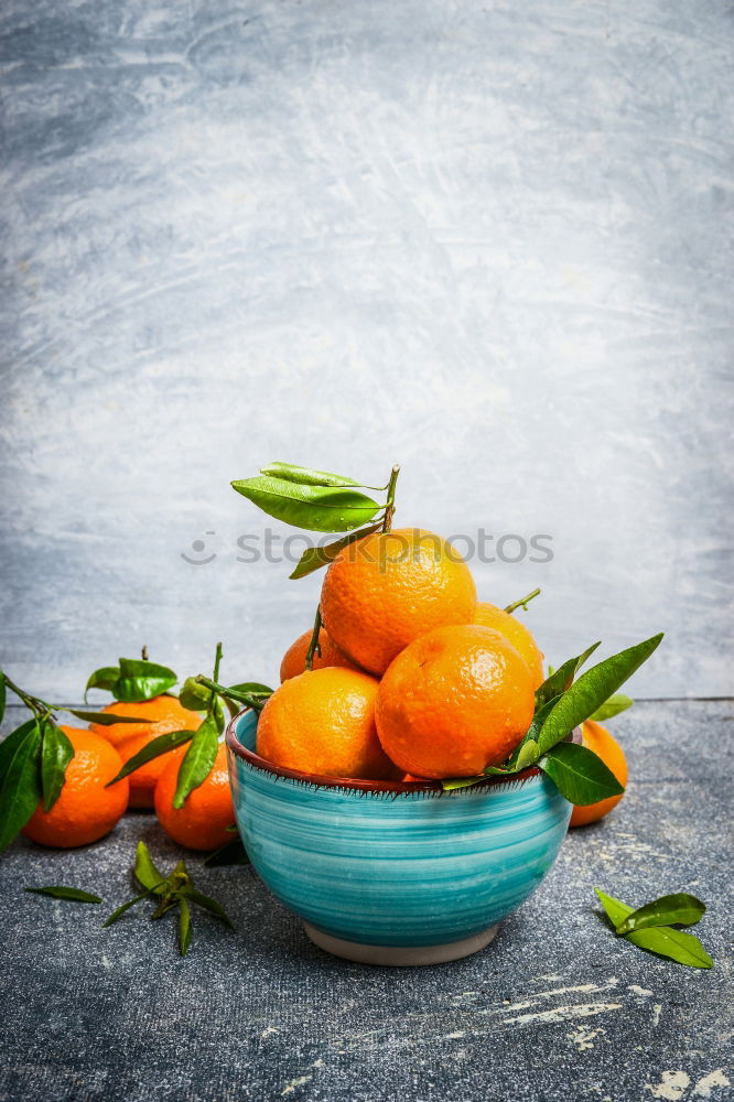 Image, Stock Photo Tangerines with green leaves in the blue bowl