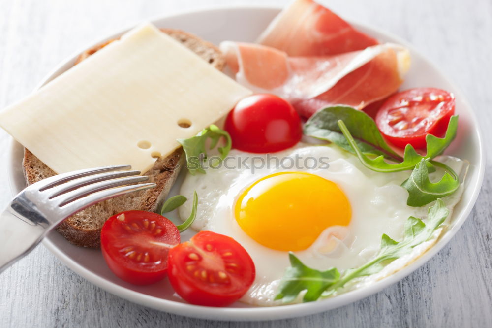 Similar – Fried egg with tomatoes and herbs on a old frying pan