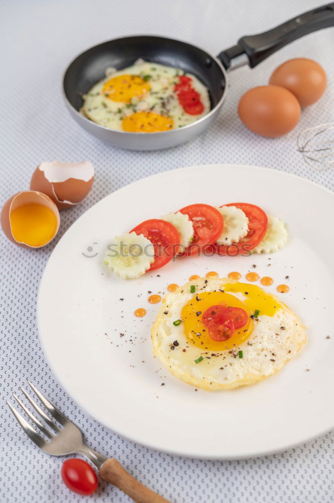 Similar – Fried egg with tomatoes and herbs on a old frying pan