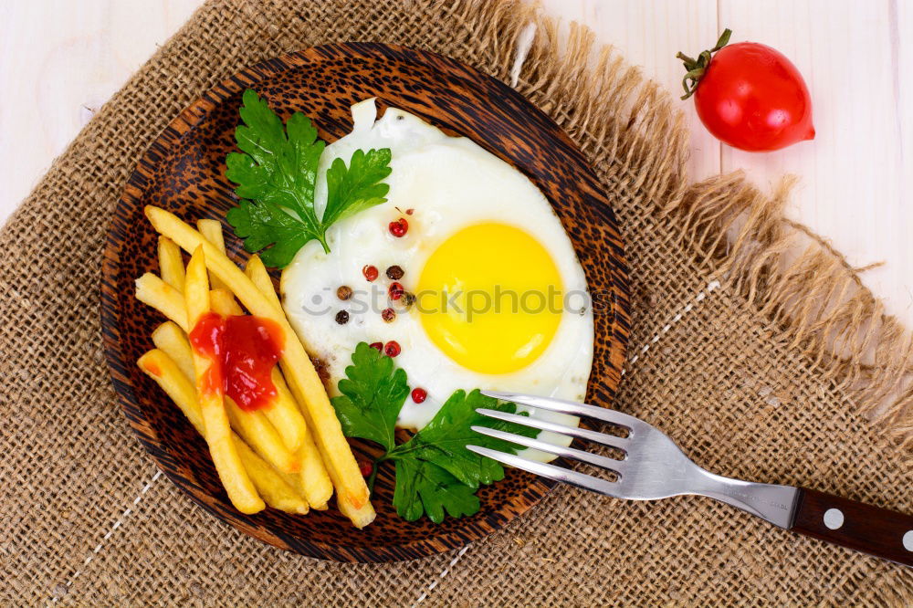 Similar – Fried egg with tomatoes and herbs on a old frying pan