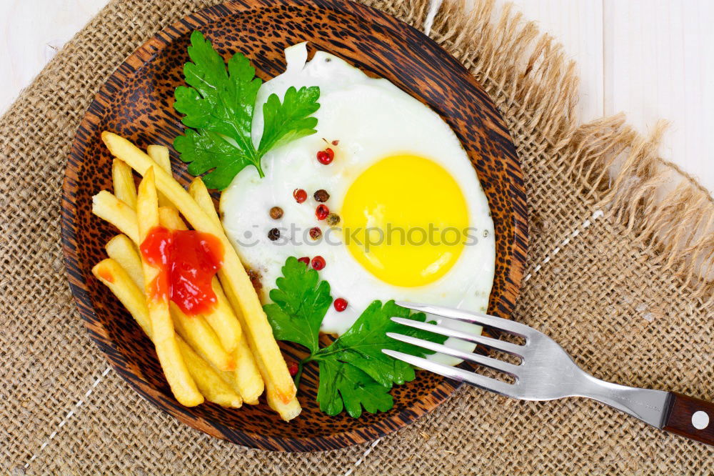 Similar – Fried egg with tomatoes and herbs on a old frying pan