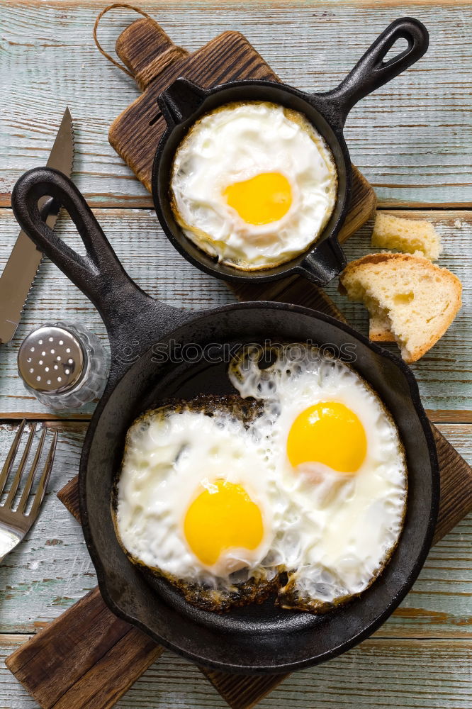 Similar – Fried egg with tomatoes and herbs on a old frying pan