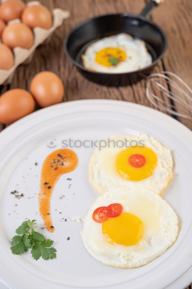 Similar – Fried egg with tomatoes and herbs on a old frying pan