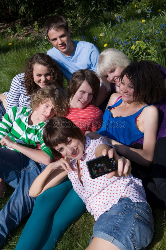 Similar – Women and men laying on grass wearing casual clothes.