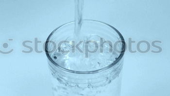 Similar – Half glass of water standing on the counter