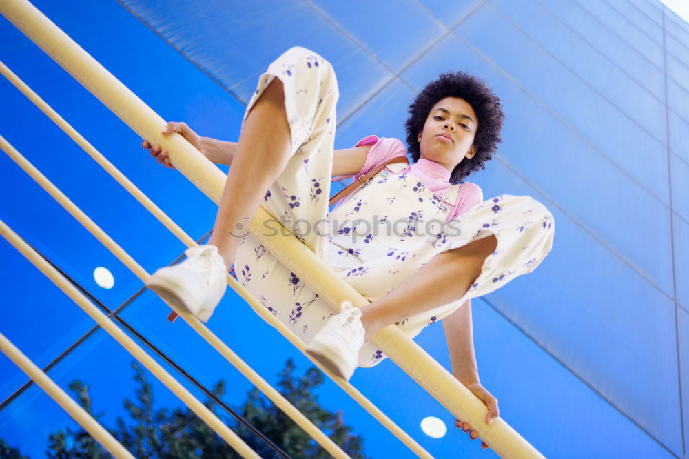 Woman with afro hair climbing by children’s attractions.