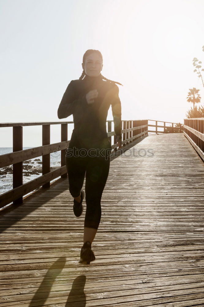 Similar – Young fitness woman runner running on city bridge.