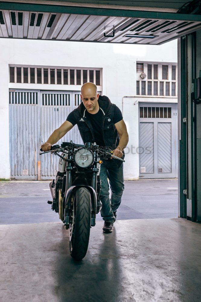 Image, Stock Photo Biker taking motorbike to the garage