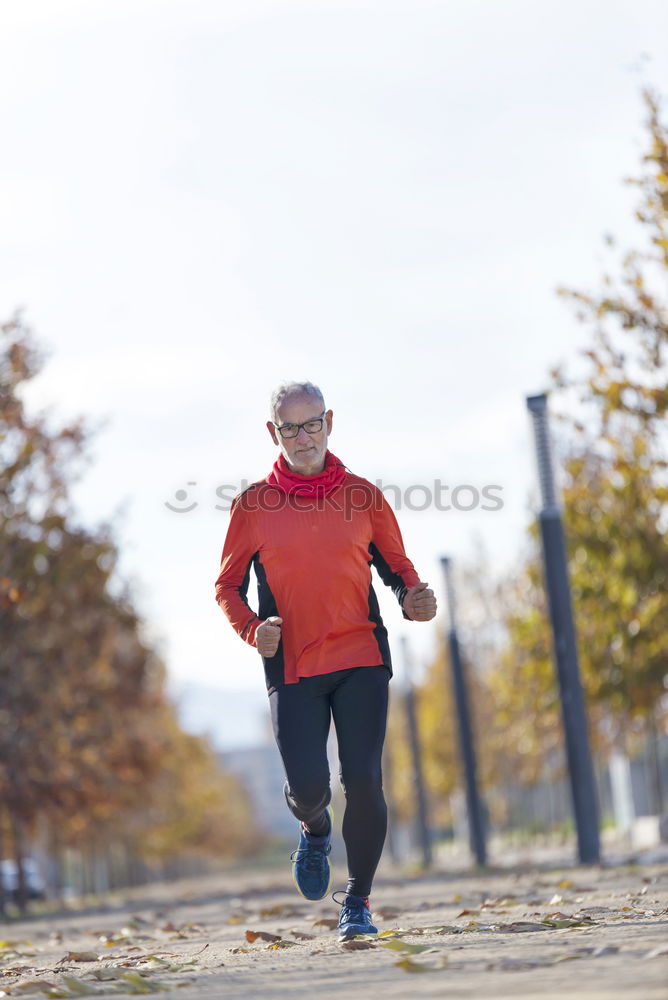 Similar – Senior runner man jumping arms up after running