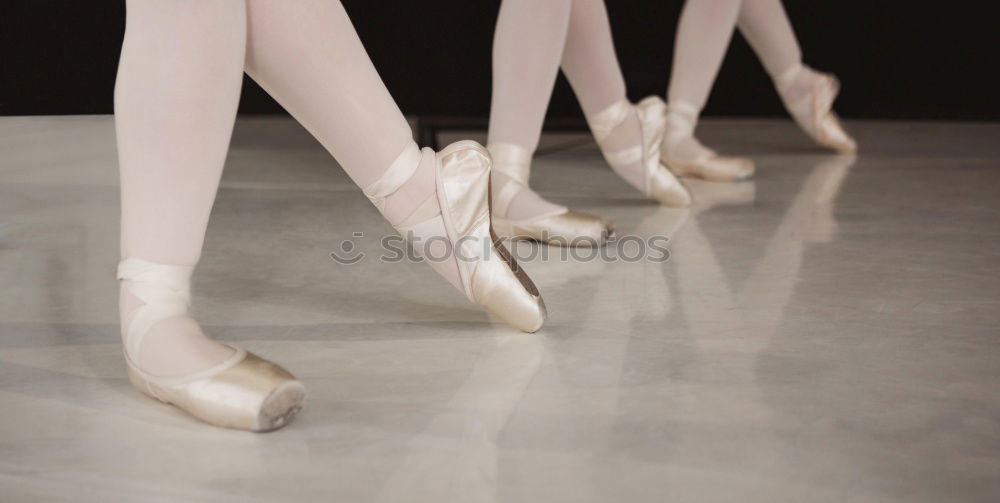 Similar – Ballerina laces up her pointe shoes