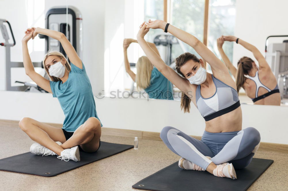 Similar – Group of young sporty attractive women in yoga studio, practicing yoga lesson with instructor, sitting on floor in forward bend yoga sana posture. Healthy active lifestyle, working out indoors in gym