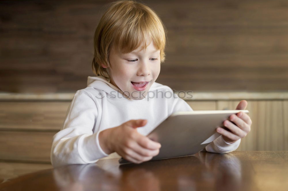 Similar – Sweet blondie girl playing on a Tablet PC.