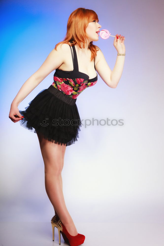 Similar – red-haired woman with black gloves in dotted dress, smiling and interlacing hands behind head