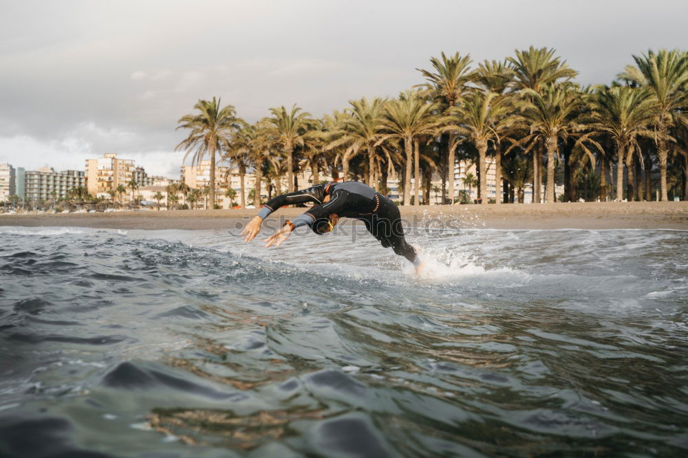 Similar – Man in wetsuit swimming in ocean