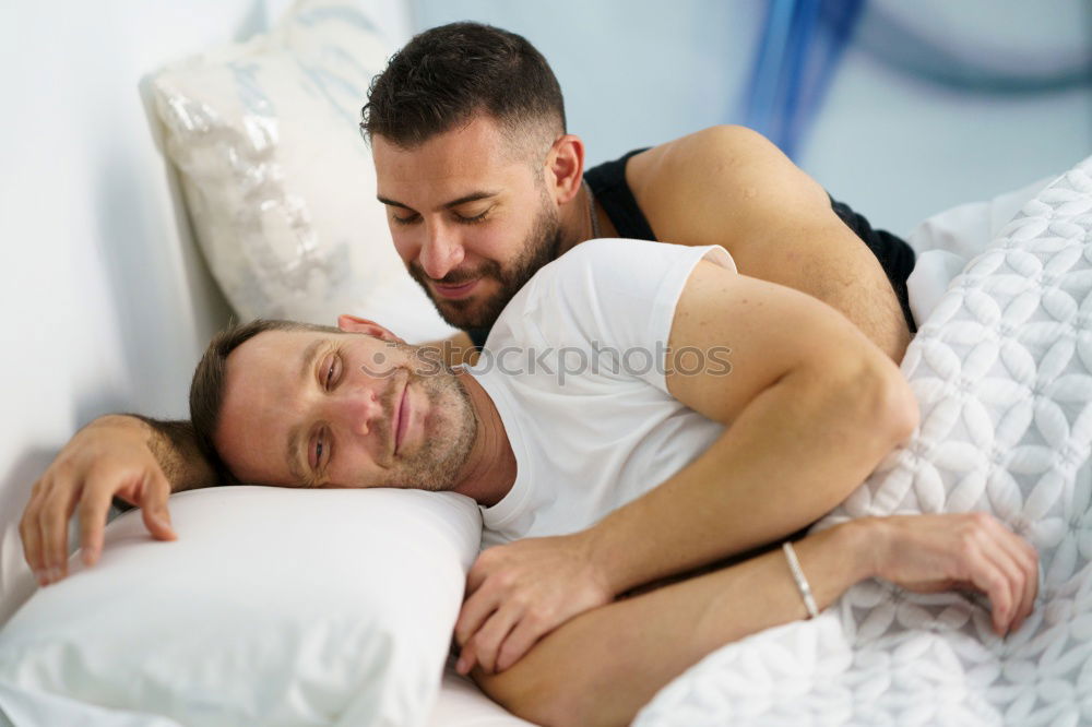 Gay couple sleeping in each other’s arms.