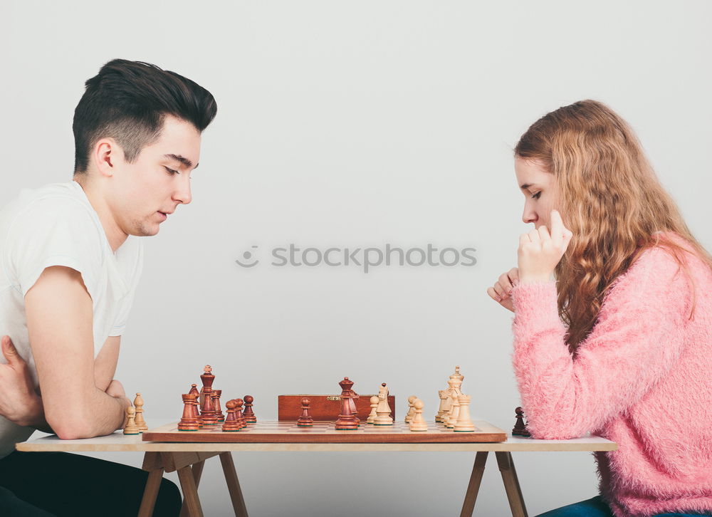 Girl and boy playing chess at home