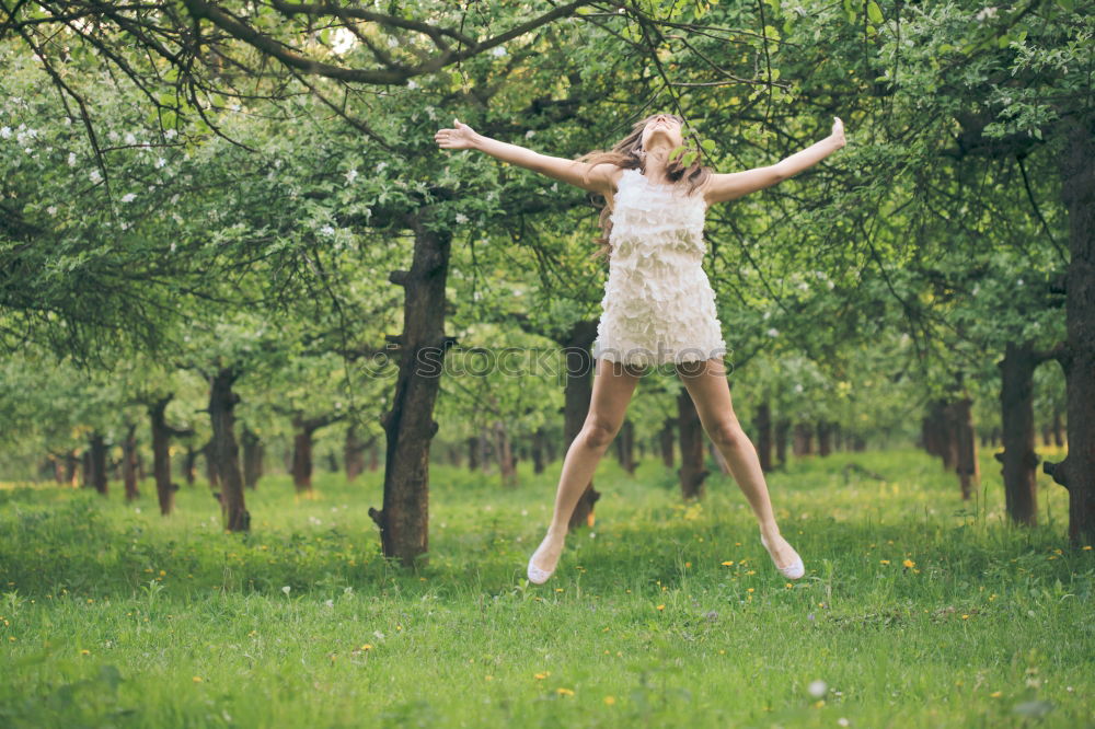 Similar – Winter ideas. Beautiful young girl stretching her finger upwards while snowing on a green meadow.