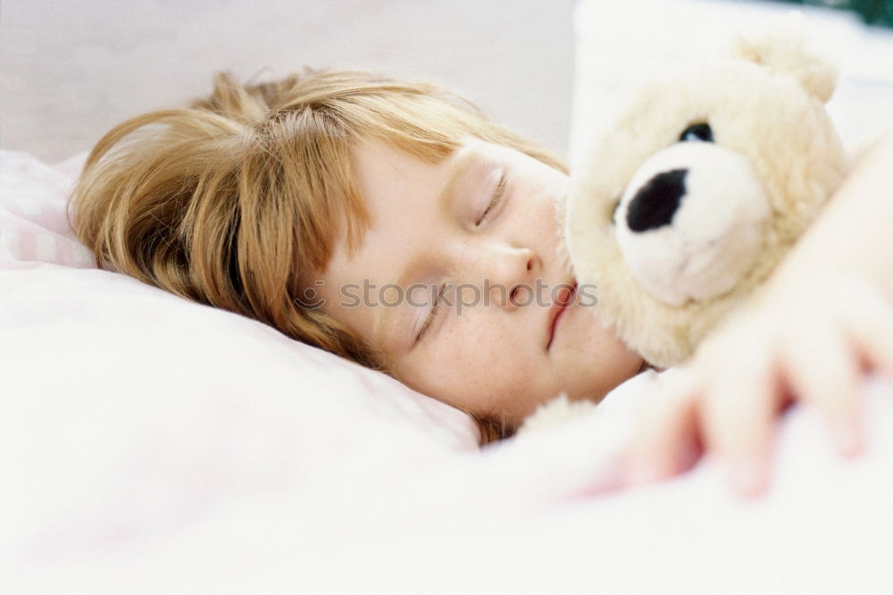 Similar – Little girl lying in a bed with teddy bear at the morning