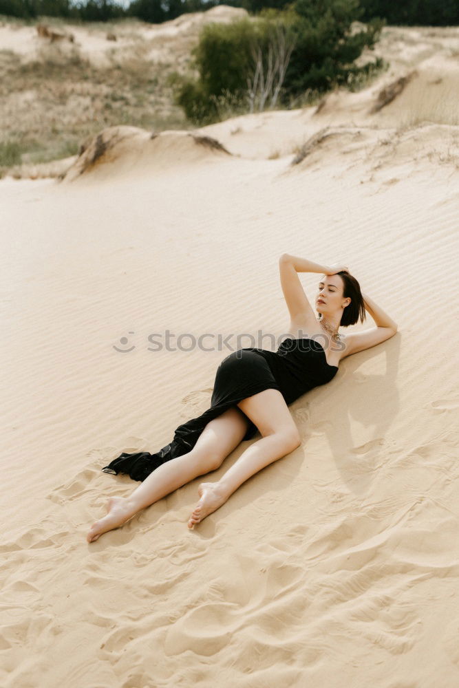 Similar – young woman with turquoise hair sits barefoot leaning against tree in beach forest and looks at camera