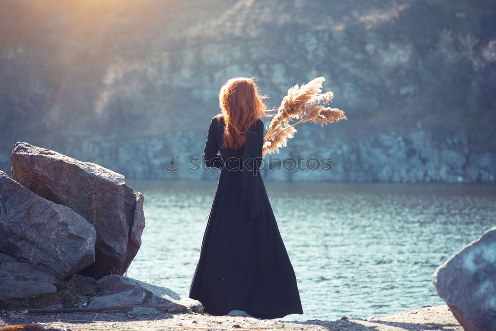 Similar – Woman looking out through a bridge, with a hand floating in the air.