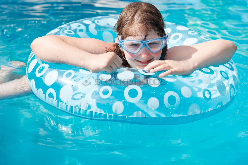 Similar – Image, Stock Photo Happy little girl floating with a ring in the water