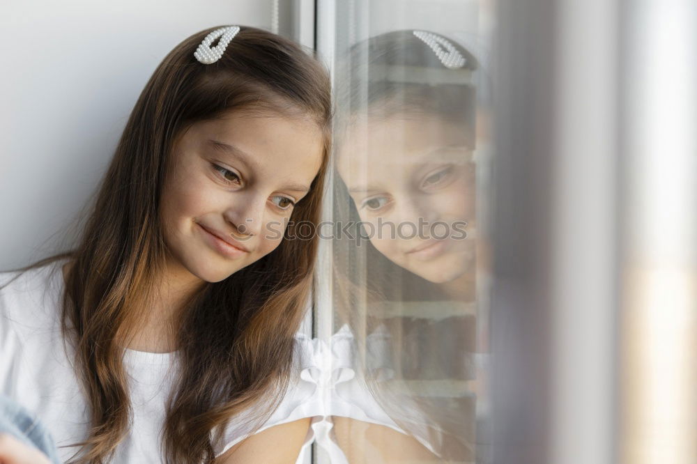 Similar – Dreaming girl looking away in window