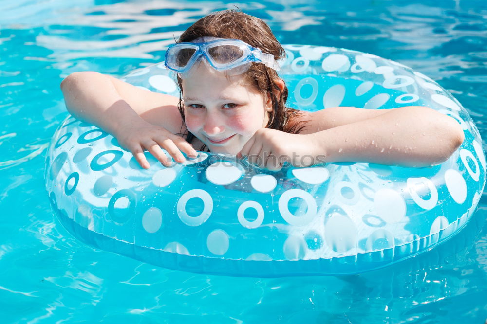 Similar – Image, Stock Photo Happy little girl floating with a ring in the water