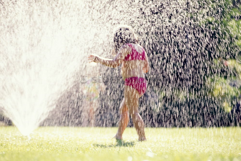 Similar – Teen girl spraying little sister in garden