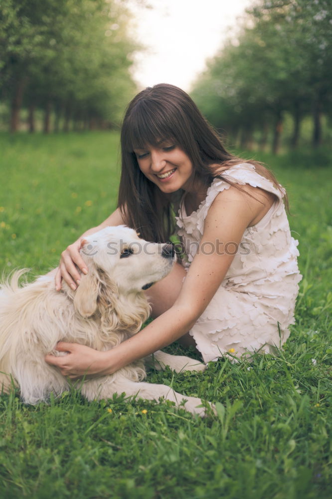 Similar – young woman with long brunette hair squats smiling on a meadow and looks at her dog