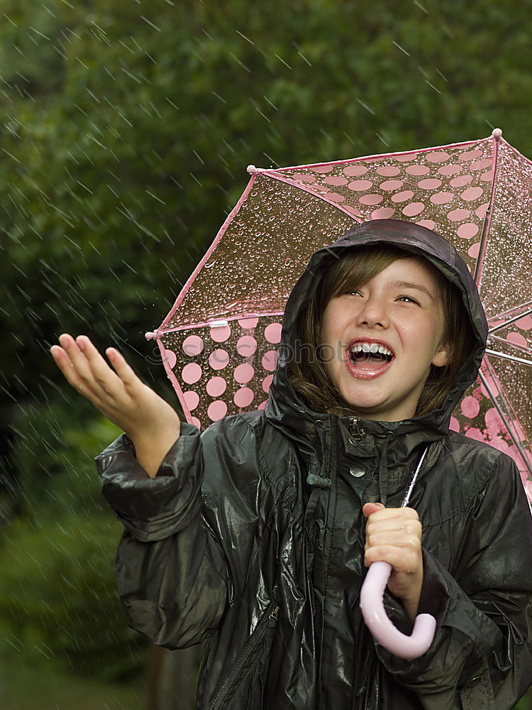 Similar – Image, Stock Photo Child in a raincoat with umbrella crouched down playing and laughing in a puddle