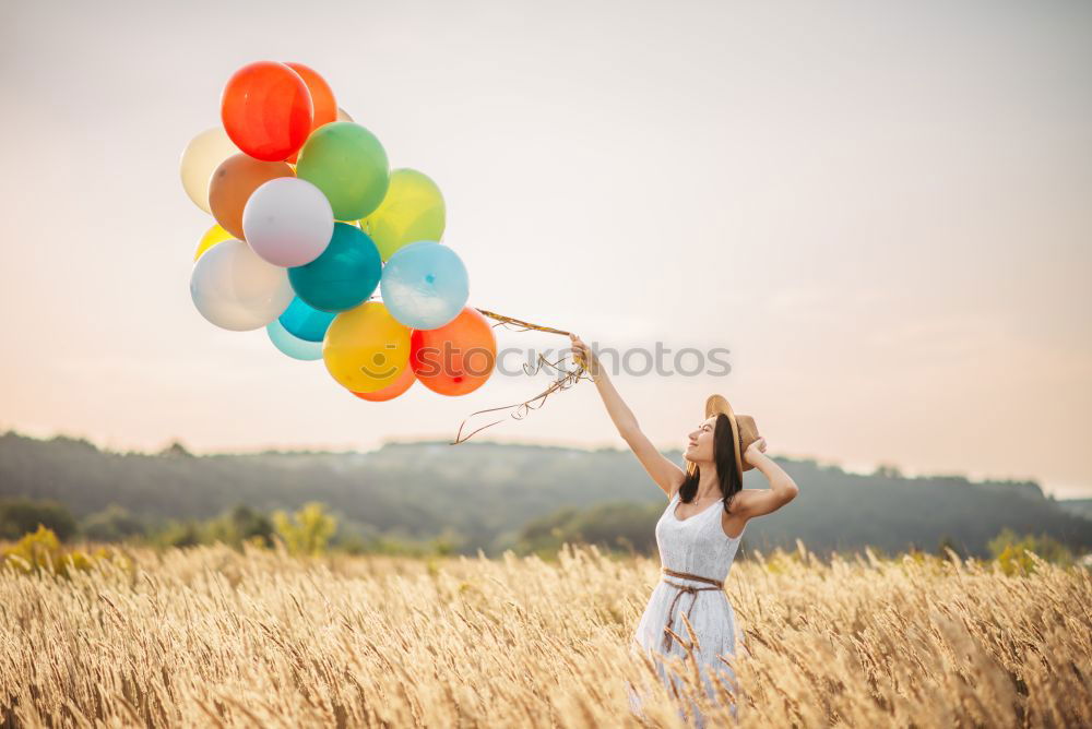 Similar – boy running through the field with balloons