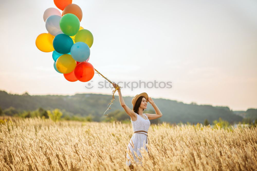 Similar – boy running through the field with balloons