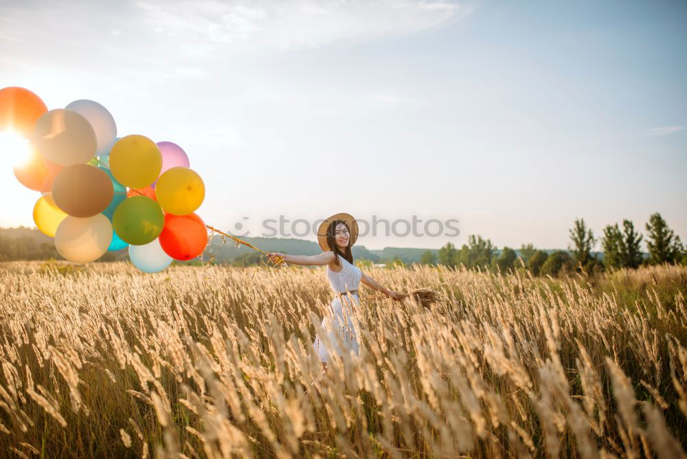 Similar – boy running through the field with balloons