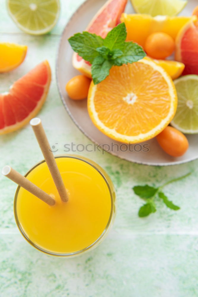 Glass of orange juice with slices of citrus fruit