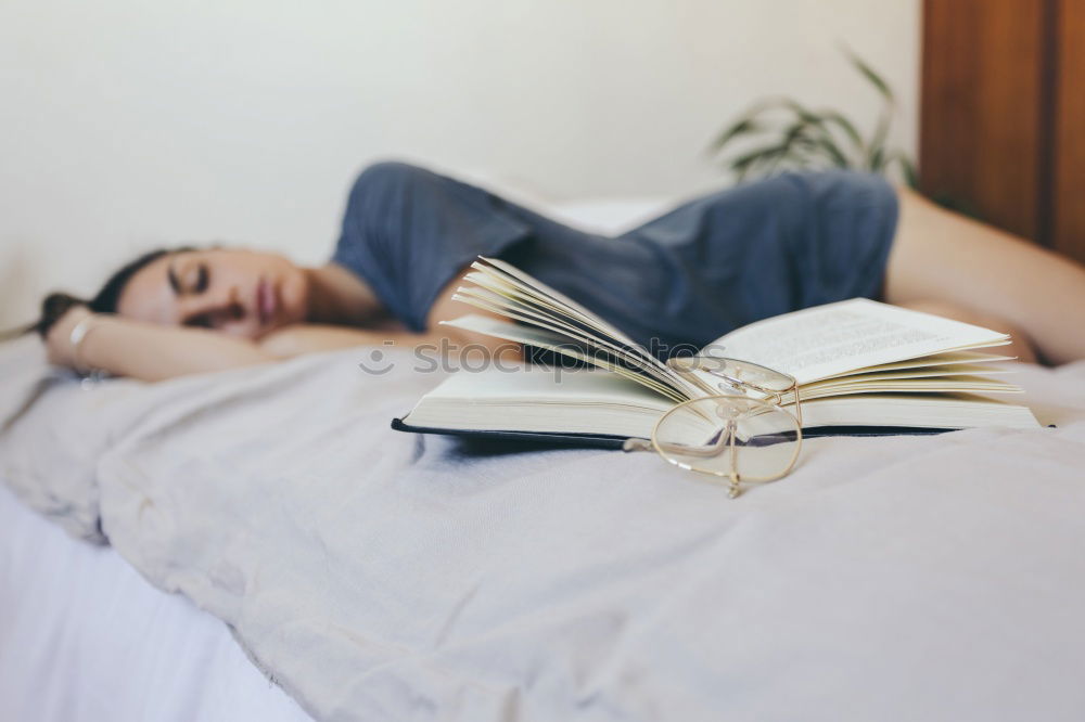 Similar – Weiches Foto von Frauenbeinen auf dem Bett mit einem alten Buch neben ihr