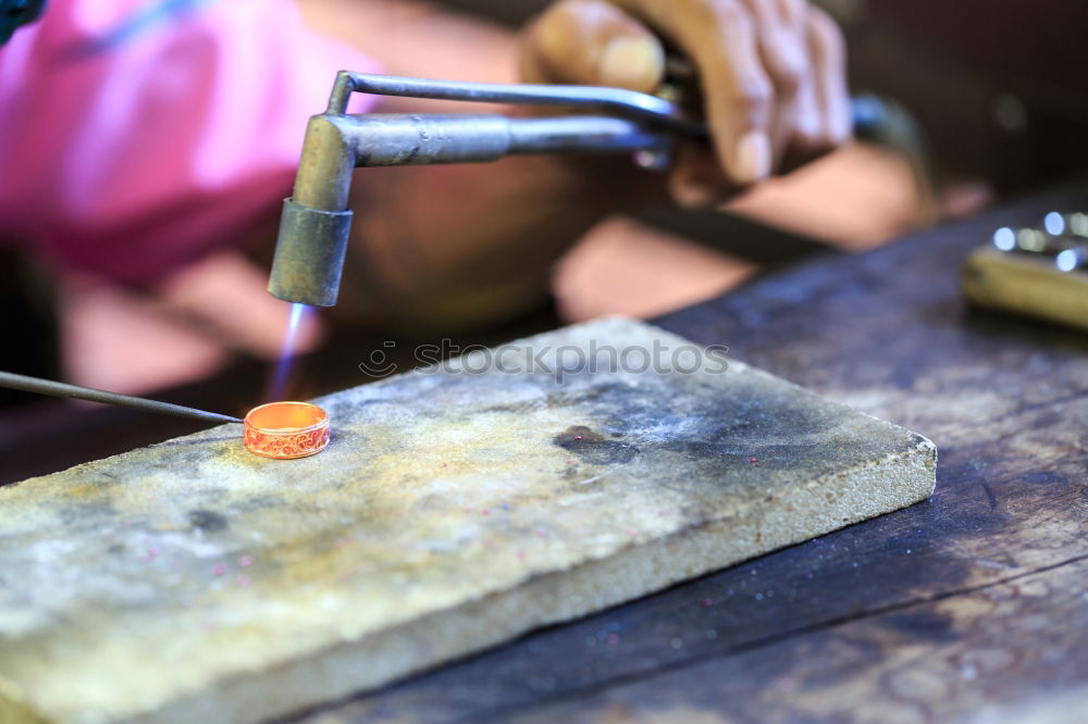 Similar – man’s hands goldsmith work on a piece of silver