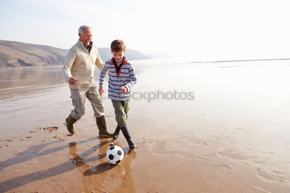 Similar – Image, Stock Photo Father and son playing football on the beach at the day time. Concept of friendly family.