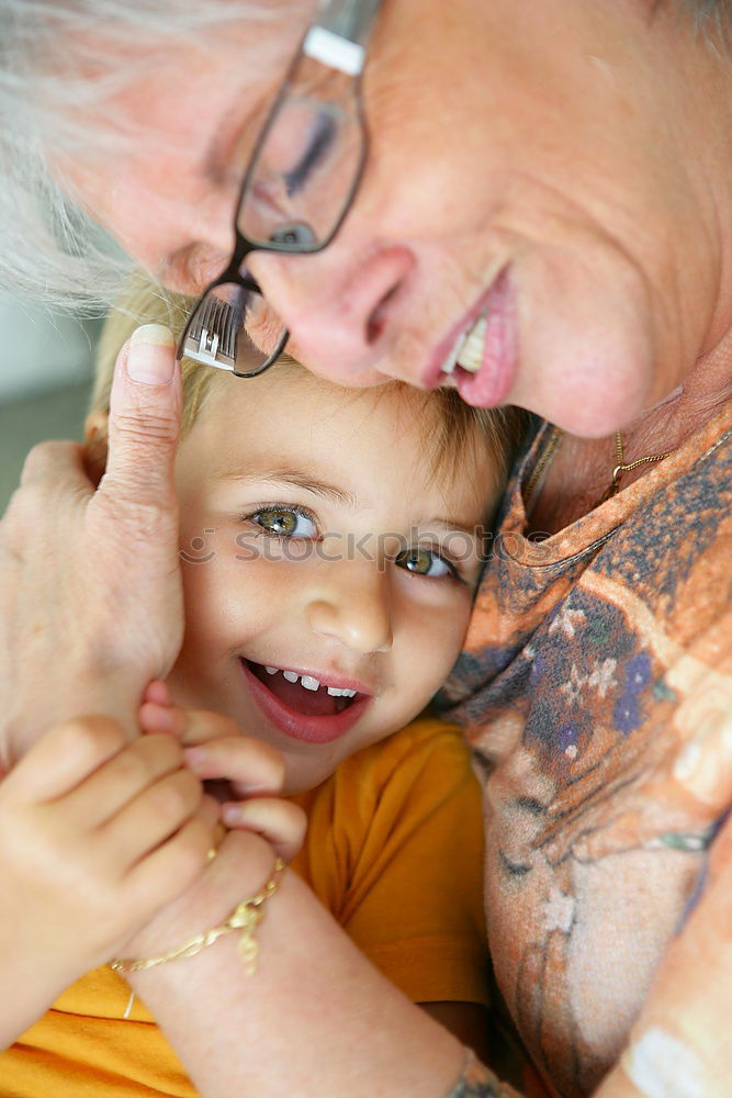 Similar – Adult woman holding a child eating a strawberry