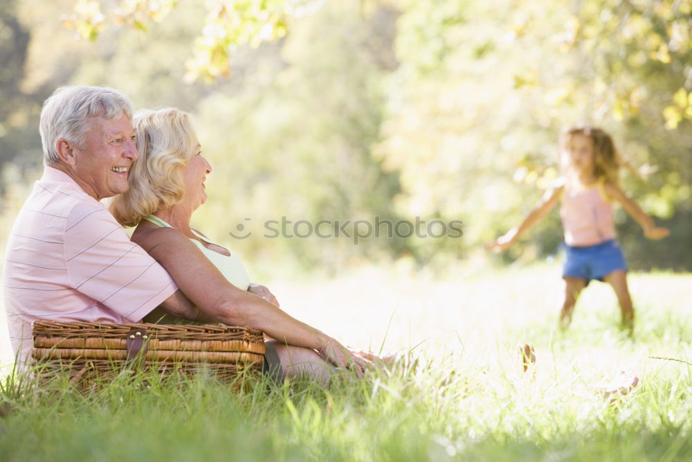 Similar – Back view of senior man holding adorable baby girl in his arms over a nature background