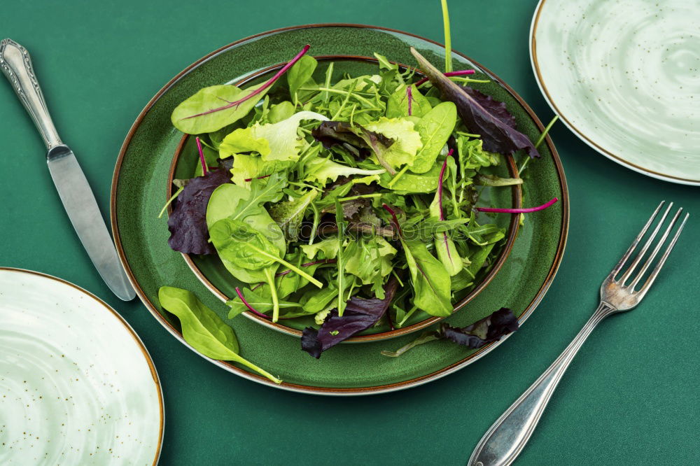 Similar – Healthy green salad with dressing on dark background