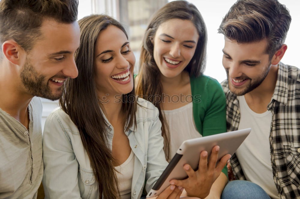 Multiracial group looking at a tablet computer outdoors